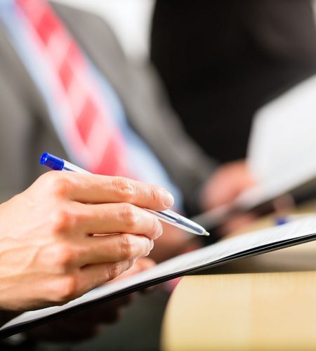 Attorney reviewing and signing real estate transaction documents at a Fort Lauderdale closing