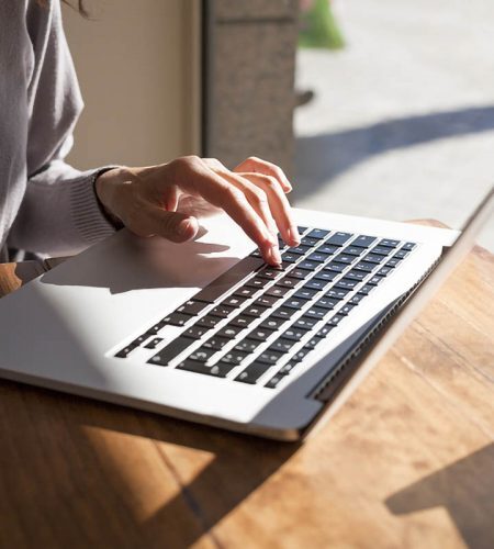 Person working on a laptop to research Fort Lauderdale real estate transactions and legal services