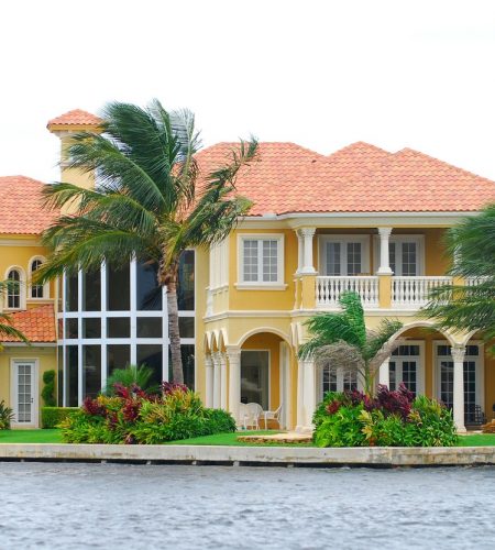 Waterfront luxury home with Mediterranean architecture and palm trees, representing estate planning and property protection in Fort Lauderdale