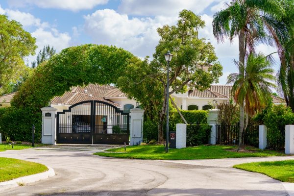 Gated luxury estate with palm trees and manicured grounds, representing high-value property estate planning in Weston
