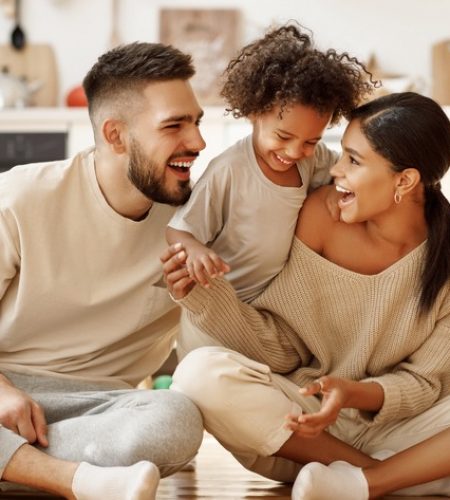 Happy family with parents and child laughing together at home, reflecting estate planning peace of mind in Weston