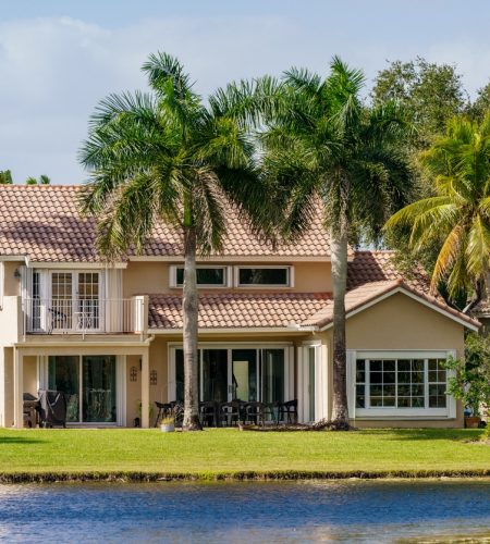 Waterfront home with palm trees and tile roof, representing estate planning for residential property owners in Weston