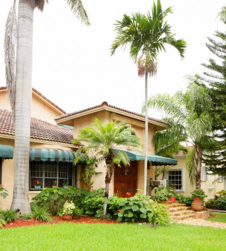 Florida ranch-style home with tile roof, palm trees, and tropical landscaping, representing real estate legal services in Boca Raton