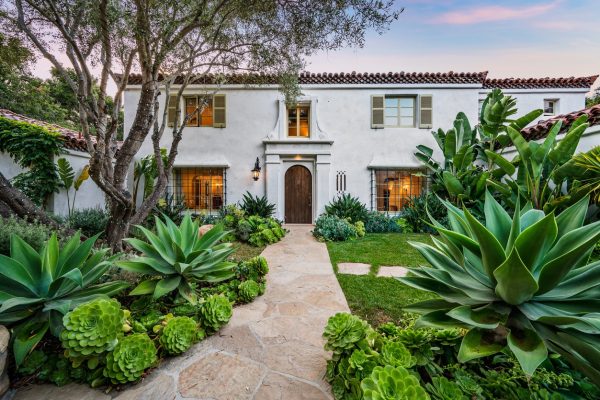 Spanish-style home with stone pathway and tropical landscaping, representing residential property estate planning in Boca Raton