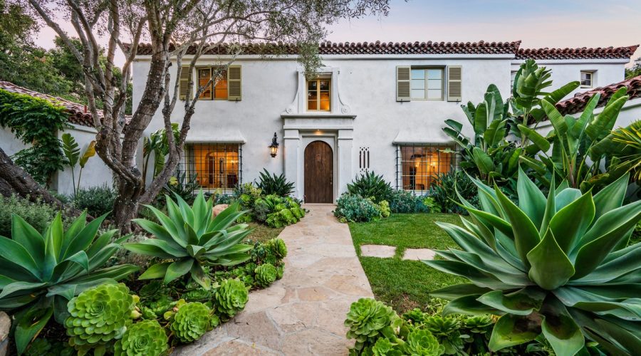 Spanish-style home with stone pathway and tropical landscaping, representing residential property estate planning in Boca Raton