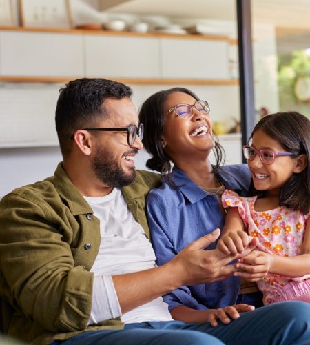 Happy family laughing together at home, reflecting the peace of mind that comes with trusted real estate legal services in Boca Raton